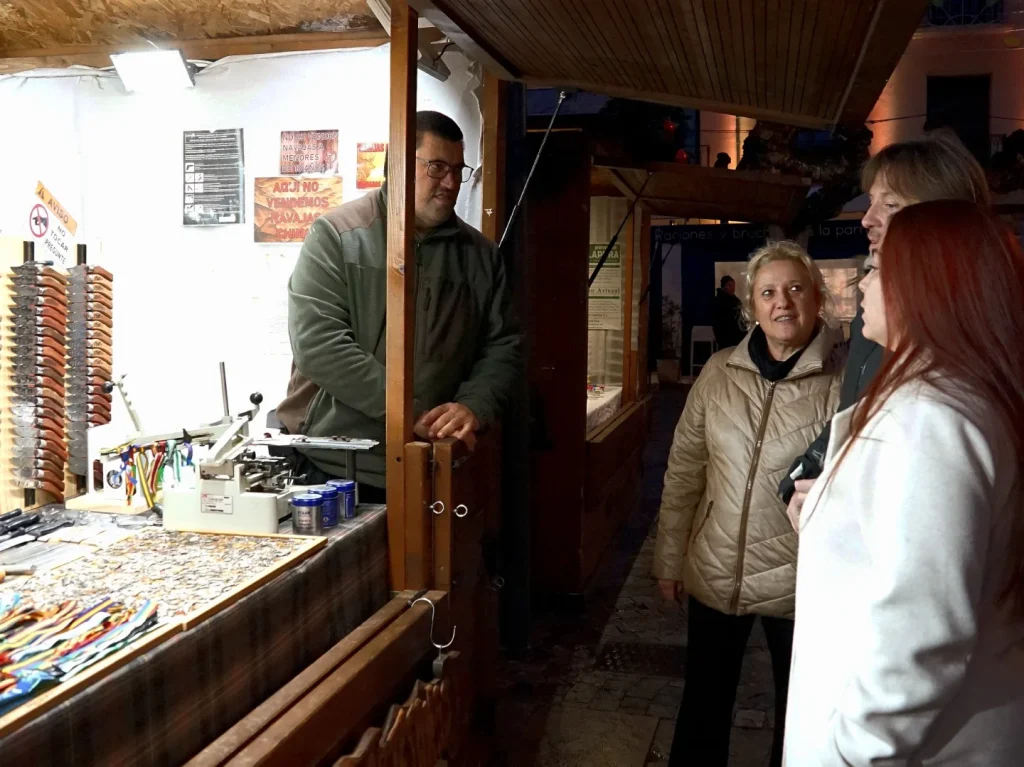 Artesano atendiendo a visitantes en su puesto del Mercado Navideño de Palencia